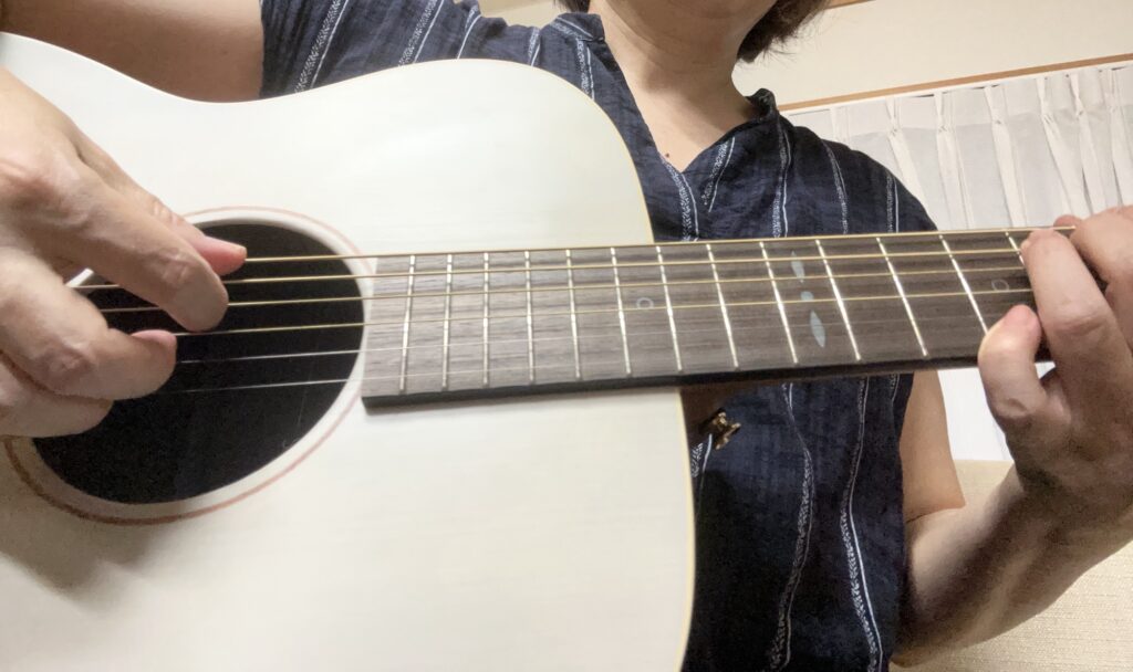 50代女性がYAMAHA STORIAⅠを抱えている写真（顔は写っていません）。ギターを始めたい方や再挑戦する方へのイメージ。