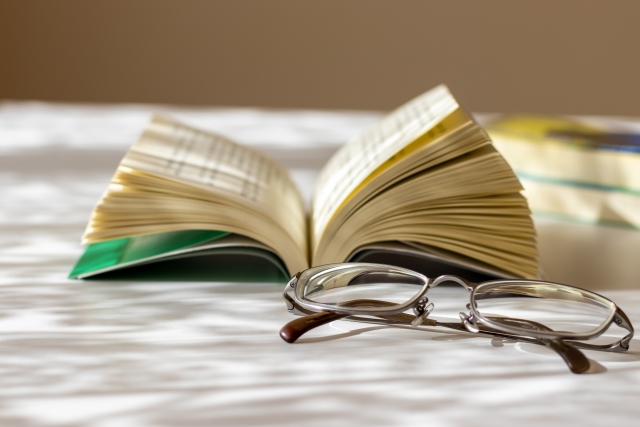 近くを見るためのメガネと本の写真