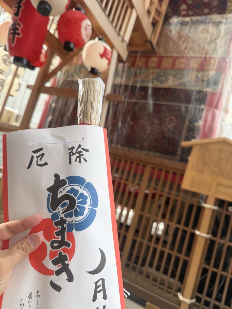 京都・祇園祭で購入した月鉾の厄除ちまきを手に持った様子