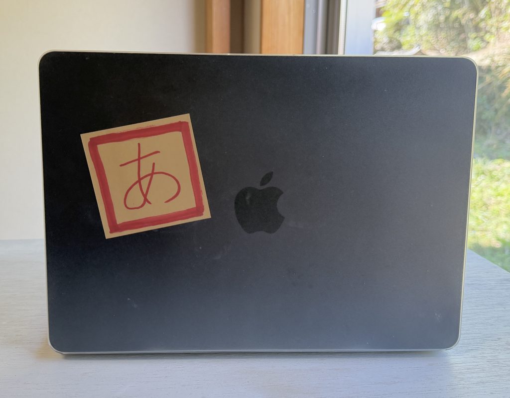 HOGOTECHのクリアマットカバーとMacBook Airの間に、手書きの「あ」を挟んだ様子